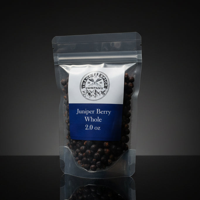 Packaged juniper berries with a label on a dark background