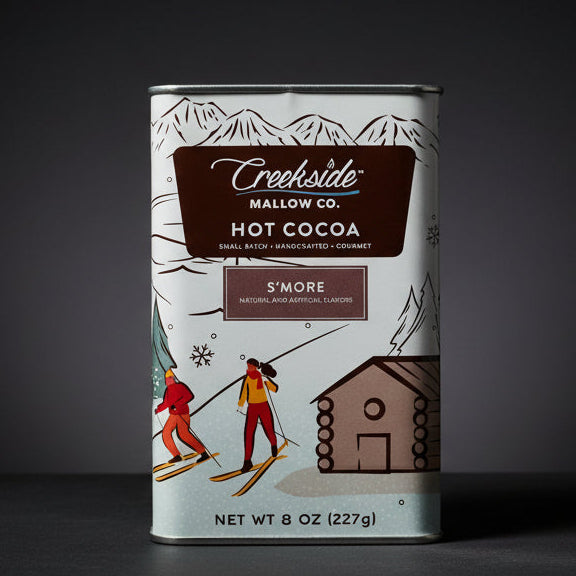 Creekside Mallow Co. hot cocoa can with skiing design on a wooden surface
