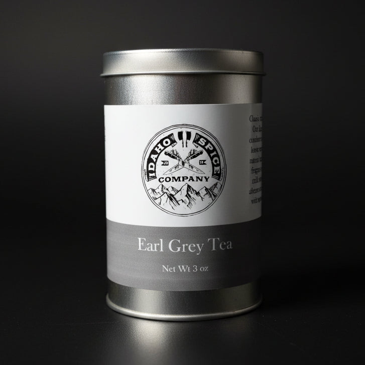 Silver tea canister with a label on a wooden surface