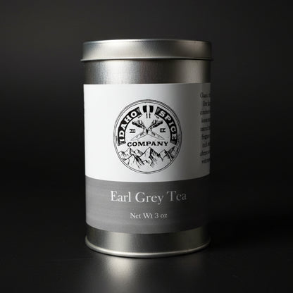 Silver tea canister with a label on a wooden surface