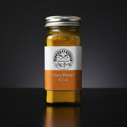 Jar of curry powder with a label on a wooden surface