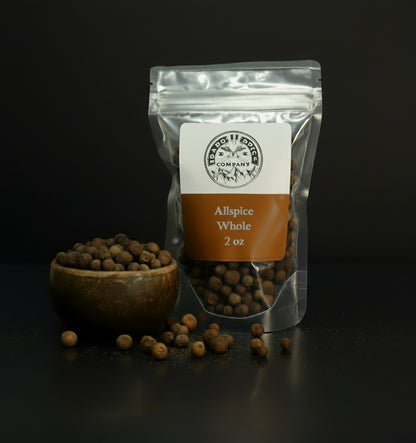 Packaged allspice whole with a wooden bowl on a dark background