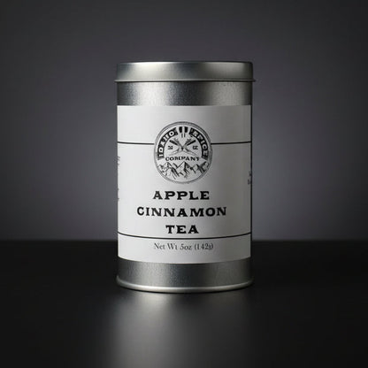 Silver canister of Apple Cinnamon Tea on a black background