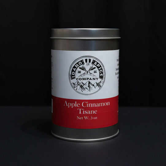 Can of apple cinnamon tea on a wooden surface with a dark fabric background