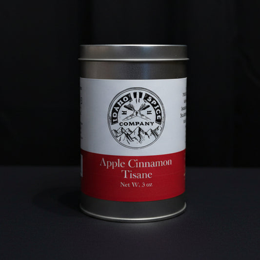 Can of apple cinnamon tea on a wooden surface with a dark fabric background