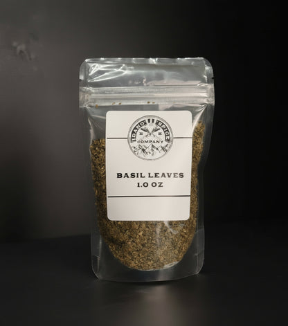 Packaged basil leaves with a label on a dark background