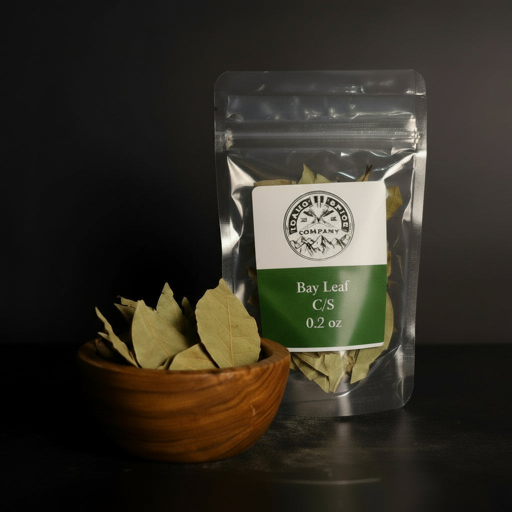 Bay leaf package with a bowl of bay leaves on a dark surface