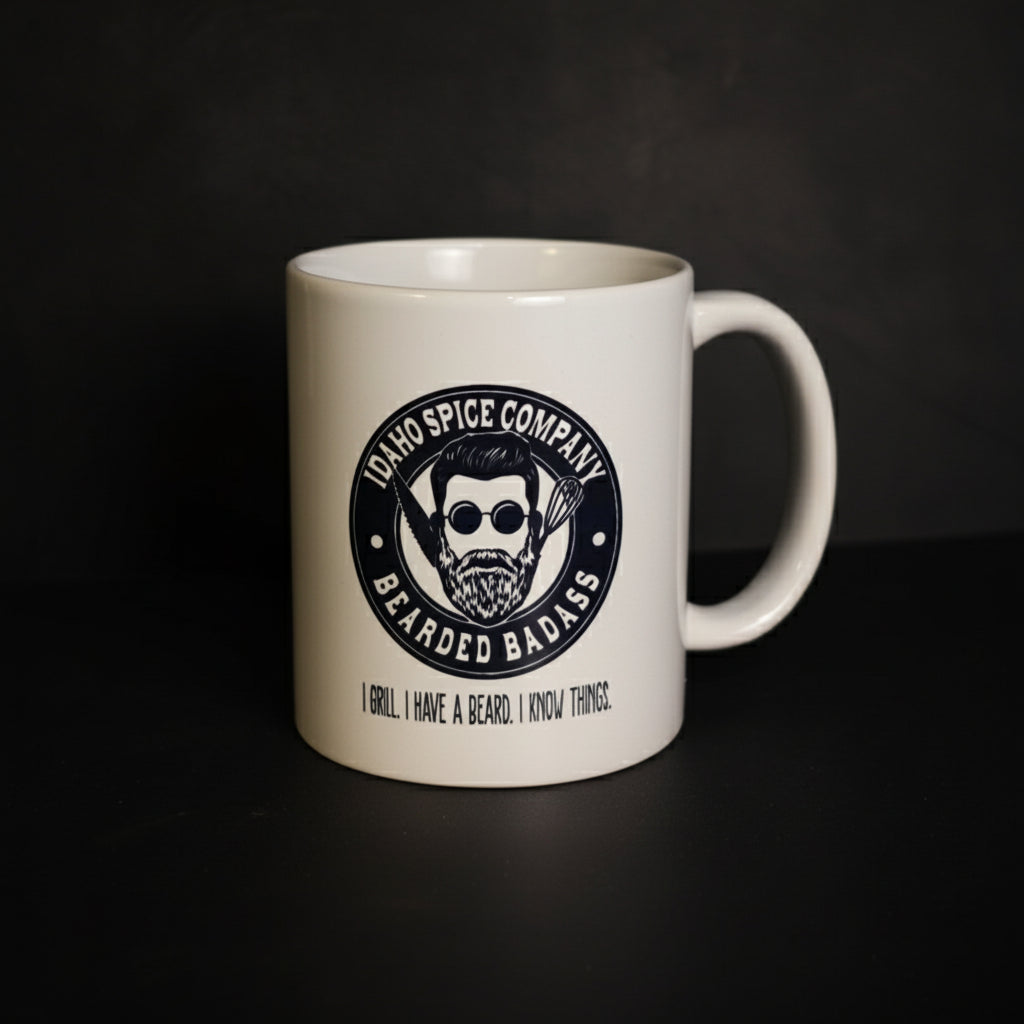 White mug with a black logo and text on a dark surface and gray background