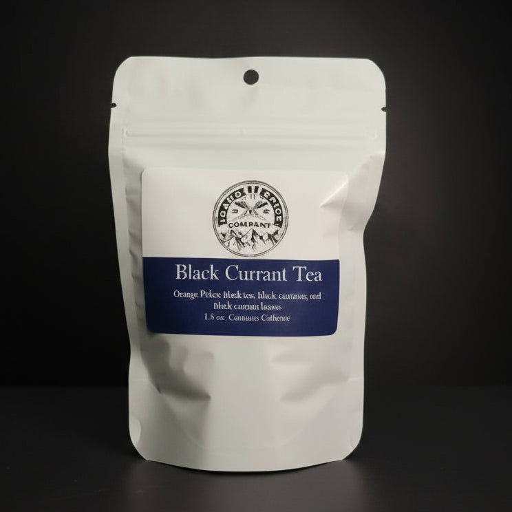 White package of Black Currant Tea with a label on a dark background