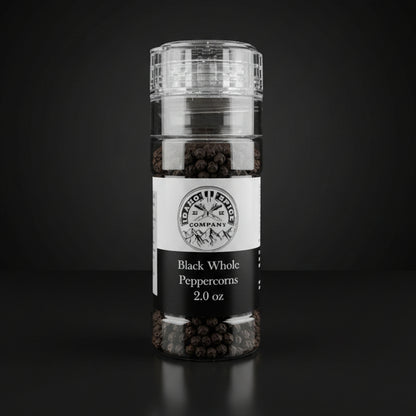 Bottle of black whole peppercorns on a wooden surface with a dark background