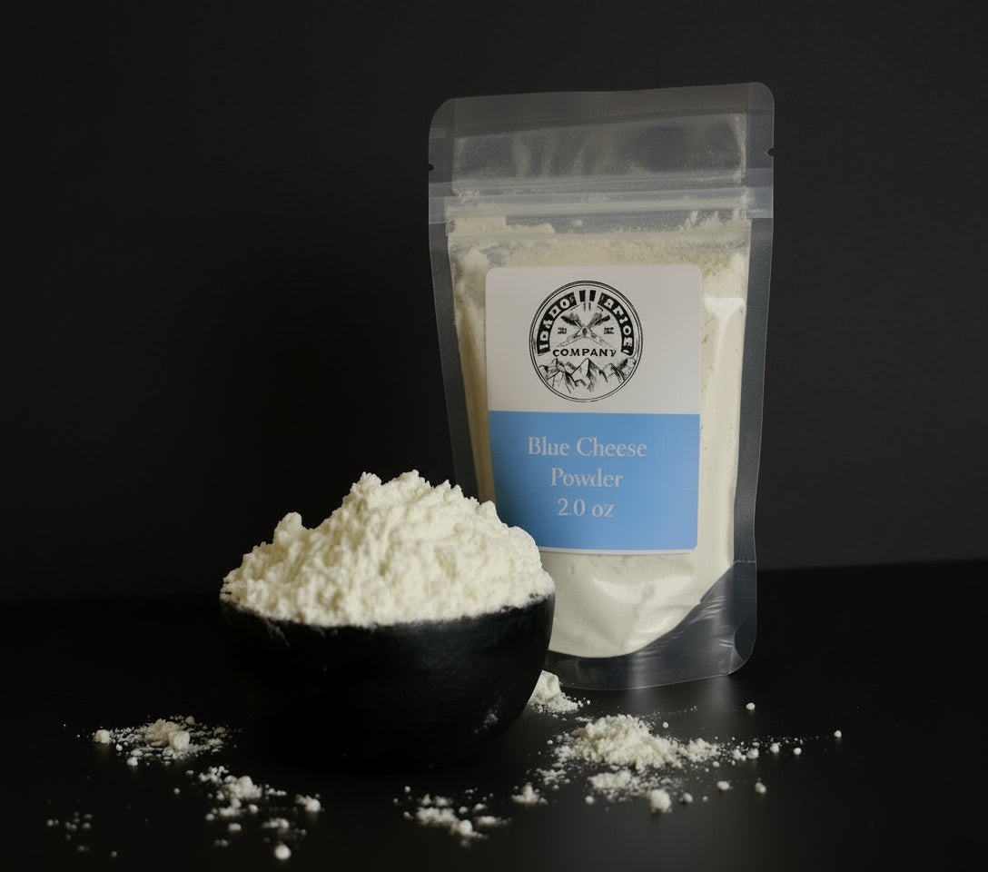 Bag of blue cheese powder with a scoop of powder on a dark surface