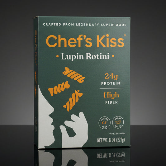 Box of Chef's Kiss Lupin Rotini pasta on a wooden surface