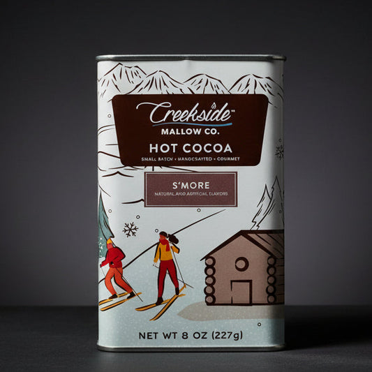 Creekside Mallow Co. hot cocoa can with skiing design on a wooden surface