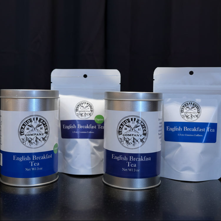 Two cans and two packages of English Breakfast Tea on a black background