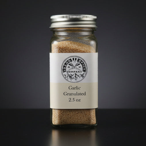 Jar of garlic granules with a label on a dark background