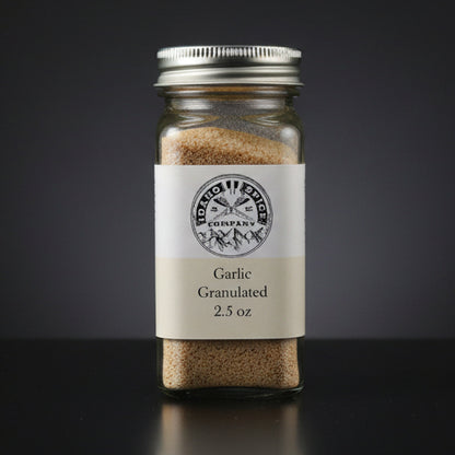Jar of garlic granules with a label on a dark background
