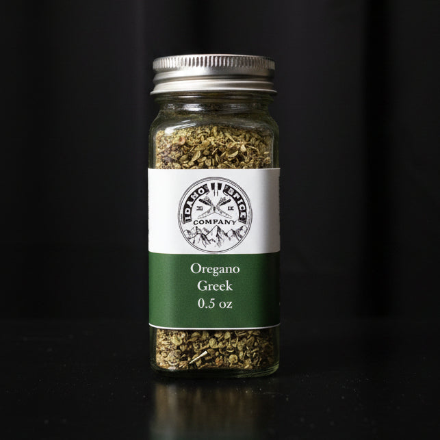 Jar of Greek oregano with a label on a black background