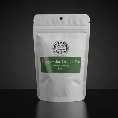 White package of Gunpowder Green Tea with a green label on a wooden surface.