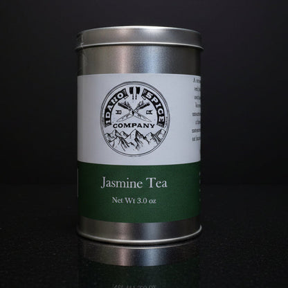 Silver tea canister with a label on a black background