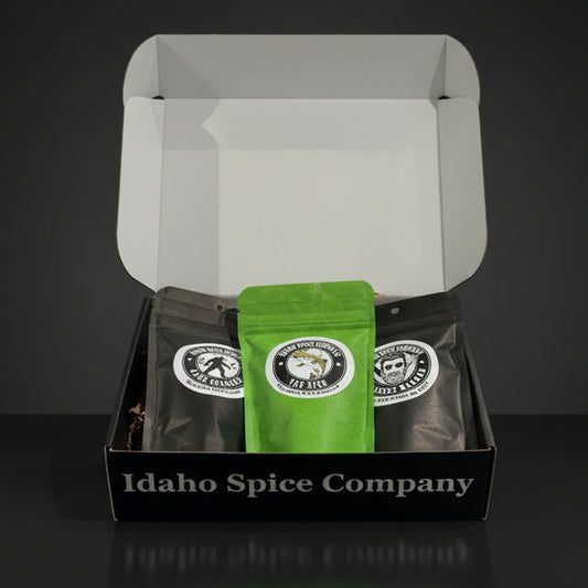 An open gift box containing three packets of different seasoning blends from Idaho Spice Company.