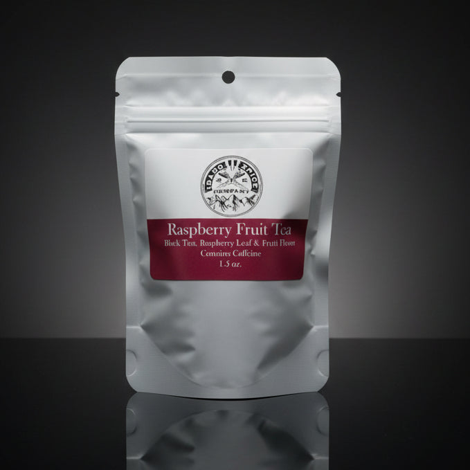 Tea package labeled 'Raspberry Fruit Tea' on a reflective surface with a dark background
